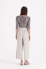 Pantalon tipo palazzo de corte amplio y tiro alto, confeccionado en tejido plisado con acabado brillante.