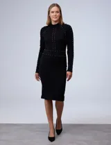 Vestido midi tejido de punto color negro, con cuello alto y mangas largas. Apliques de perlas doradas en el frente y la espalda.