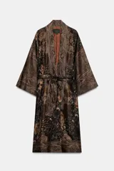 Chaqueta larga tipo kimono de Zara, confeccionada en mezcla de lino y seda con diseño jacquard estampado en tonos marrones y oscuros, manga larga y cinturón ajustable del mismo tejido.