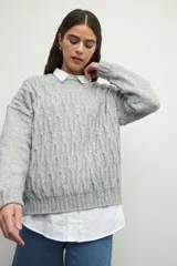 Sweater de tejido tramado en color verde oliva, con cuello redondo y mangas largas. Presenta un diseño de textura acanalada vertical.