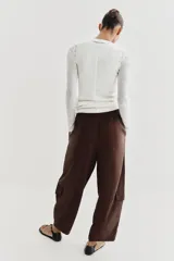 Pantalón de tiro medio con cintura elástica ajustable con cordón. Presenta un diseño de paneles laterales en tejido técnico contrastante y bolsillos tipo cargo. Su corte es holgado con pernera que se estrecha hacia el tobillo.