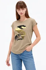 Remera de algodón color verde militar, con mangas cortas con dobladillo y estampado frontal abstracto con detalles en foil dorado y negro.
