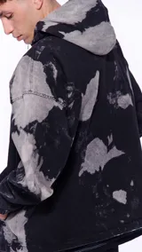 Canguro con capucha de denim negro con manchas grises, cierre frontal parcial con cremallera y bolsillo tipo canguro.