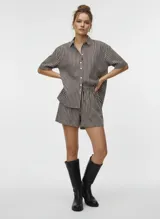 Short de tiro alto con cintura elástica, confeccionado en tejido plano con rayas verticales en tonos oscuros (marrón/negro) y blanco, con un acabado que simula un efecto brillante o foil.