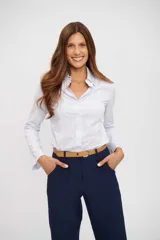 Camisa de vestir blanca con finas rayas verticales celestes, de manga larga y cuello camisero. Corte ajustado al cuerpo.