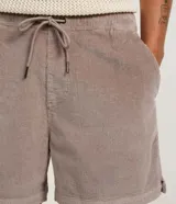 Bermuda masculina tipo runner de terciopelo cotelé, color beige, con cintura elástica, cordón ajustable y bolsillos laterales.
