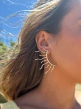 Aro plateado en forma de sol con rayos.