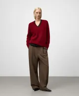 Jersey de punto para mujer, color rojo oscuro, con cuello en V y manga larga. Presenta un acabado afelpado y holgado, con remates en canalé.