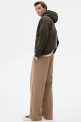 Canguro de corte holgado con capucha forrada y cordón de ajuste. Presenta hombros caídos, bolsillo frontal tipo canguro y terminaciones acanaladas en puños y ruedo. Confeccionado en mezcla de algodón con interior suave.