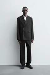 Blazer de corte regular confeccionada en tejido de lana italiana. Presenta cuello con solapas de pico, cierre frontal de botonadura cruzada, manga larga con puños abotonados, bolsillos de vivo en el pecho y bolsillos de solapa en la cadera.