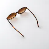 Lentes de sol con armazón ovalado de carey y cristales marrones degradados.