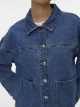 Campera de denim estilo shacket en color azul claro, con cuello clásico, cierre frontal con botones metálicos y amplios bolsillos frontales aplicados.