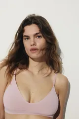 Soutien de diseño seamless, confeccionado en tejido suave de color rosado. Presenta copas forradas con relleno extraíble, breteles ajustables y una banda elástica inferior para mayor sujeción. Su diseño carece de aros y cierres, priorizando la comodidad.