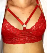 Bralette rojo de encaje con tiras finas y aros metálicos.