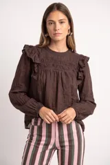 Blusa marrón de manga larga con volados en los hombros, detalles de encaje en el pecho y cuello redondo.