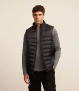 Chaleco masculino deportivo tipo puffer, color negro, con cuello alto, gajos acolchados y cierre delantero con cremallera.