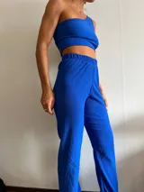 Pantalón de corte recto y tiro alto, confeccionado en tela con textura arrugada, color azul vibrante, con cintura elástica.