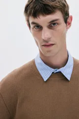 Buzo de punto acanalado color marrón, de manga larga y cuello redondo, con corte estándar y bajo recto.