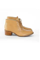 Botines acordonados de cuero vacuno color camel texturizado, con puntera ligeramente puntiaguda y tacón bloque de madera clara de 6 cm.