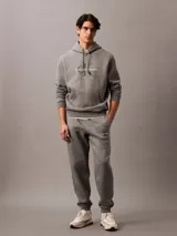 Pantalón de jogging gris con cintura elástica, bolsillos laterales y logo de Calvin Klein Jeans en la pierna. Confeccionado en mezcla de algodón y poliéster.