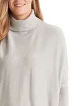 Polera de tejido de punto color negro, con cuello alto, corte oversize y mangas largas con puños elastizados.