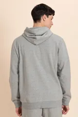 Campera deportiva con capucha, confeccionada en tejido de punto color gris melange, con puños y ruedo acanalados.