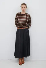 Falda midi de denim color gris oscuro, con corte evasé y costuras a contratono que definen su estructura. Presenta una cintura elástica para mayor comodidad.