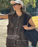 Bolso tipo tote de diseño urbano, confeccionado en material impermeable acolchado de color negro. Cuenta con doble asa de hombro, compartimento principal con cierre, bolsillo frontal con cierre y detalle de logo circular en la parte superior.