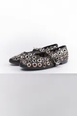 Ballerinas negras de cuero sintético con correa sobre el empeine y hebilla metálica. Diseño con múltiples ojalillos metálicos.