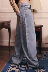 Jean de corte baggy y tiro bajo, en color azul lavado. Presenta un diseño holgado con presillas anchas en la cintura y estilo carpenter.