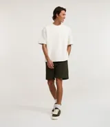 Bermuda masculina de algodón con felpa, color negro, corte slim fit. Presenta cintura elástica con cordón ajustable, bolsillos y etiqueta aplicada.