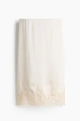 Pollera midi de tiro alto con cintura elástica y detalle de encaje en el ruedo.