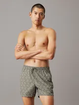 Short de baño verde con estampado del logo de Calvin Klein en blanco. Tiene cintura elástica con cordón ajustable, bolsillos laterales y un bolsillo trasero.