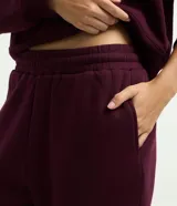 Pantalón jogger de mujer confeccionado en tejido fleece de algodón y poliéster. Presenta un corte holgado con cintura elástica y puños ajustados en el bajo.