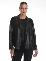 Campera estilo biker confeccionada en cuero sintético con paneles de neopreno en los laterales. Presenta cuello con solapas, cierre frontal cruzado, bolsillos inclinados y mangas largas con cierre metálico en los puños.