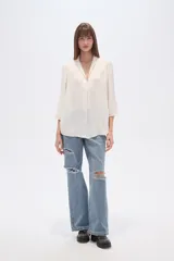 Blusa de poliéster color negro, con cuello en V, corte holgado y mangas tres cuartos.