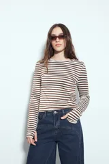 Remera de manga larga con diseño de rayas horizontales en color marrón y blanco, cuello redondo y corte ajustado al cuerpo.