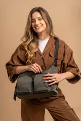 Bandolera de tafeta impermeable color beige, con dos bolsillos frontales con cierre y correa regulable. Diseño práctico y liviano ideal para uso diario.