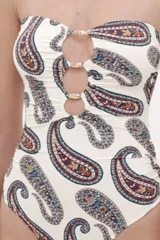Malla enteriza de color blanco con estampado paisley en tonos azules, marrones y rojos. Presenta diseño bandeau con tirantes finos ajustables, escote con aberturas circulares unidas por argollas metálicas doradas.