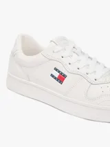 Zapatillas bajas de cuero y sintético en color blanco, con diseño de cordones, suela de goma y detalles de la marca Tommy Jeans.