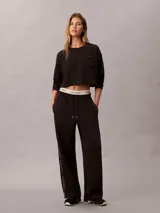 Top cropped de manga larga Calvin Klein, confeccionado en punto de algodón. Presenta cuello redondo, hombros caídos y un bolsillo de parche en el pecho con el logo de la marca bordado.