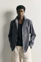 Camisa de corte regular fit confeccionada en tejido de algodón, con cuello solapa, manga larga con puños abotonados, bolsillo plastrón en el pecho y cierre frontal de botones.