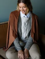 Camisa blanca de manga larga, corte holgado, con cuello con solapa, abertura central con botones y bolsillo aplicado en el pecho.