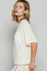 Remera de manga corta con diseño holgado, cuello redondo y bolsillo frontal aplicado en el pecho.