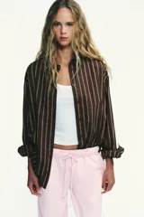 Pantalón de felpa de tiro alto con cintura elástica y corte recto. Cuenta con bolsillos laterales ocultos en la costura y bajo ajustable con cordón elástico y stoppers.