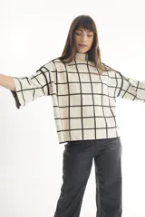 Sweater de punto con cuello alto y manga corta, con estampado de cebra en blanco y negro.