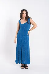 Vestido largo de tejido de punto azul con brillo, sin mangas, escote cuadrado y diseño acampanado.