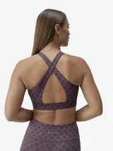 Top deportivo de cuello redondo con espalda estilo nadador, confeccionado en tejido técnico compacto y ligero con estampado de monograma BORN. Cuenta con copas extraíbles y banda elástica inferior para mayor sujeción.