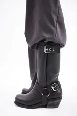 Bota de cuero marrón con caña alta y estribo desmontable.