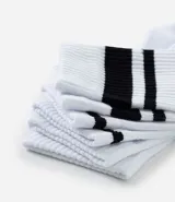 Kit de tres pares de medias deportivas Puma de caña larga, color blanco con detalles en negro. Incluye logo de la marca y diseño con rayas en la parte superior.